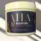 Jar of AHA Body Booster Bright Serum with a dark label and gold text.